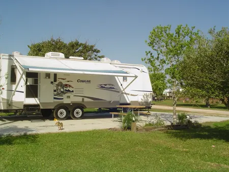 A travel trailer set up on a concrete pad site